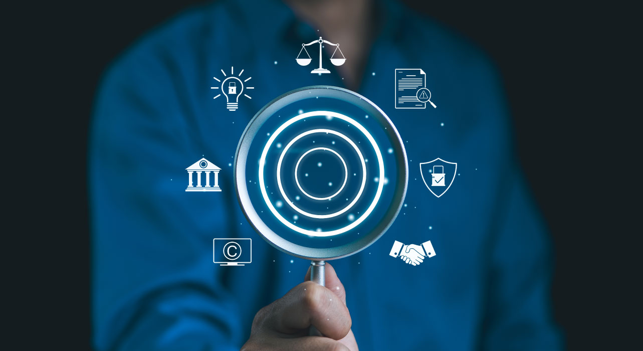 Person in a blue shirt holds a magnifying glass with digital icons, including scales, lightbulb, and shield